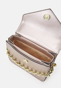 Metallic różowa torebka na ramię z złotym łańcuszkiem, zatrzaskiem i gładką fakturą. Wewnątrz znajduje się dwie komory i podszewka z logo marki.