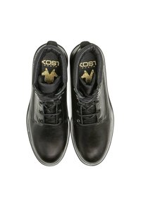 Bottes en cuir noir avec une texture lisse, dotées de lacets ronds, d'un logo doré sur la languette et d'un design à bout arrondi.