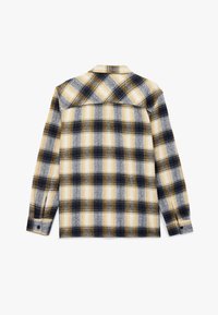 Flannel skjorte med et ternet mønster i sort, gul og hvid. Lange ærmer og krave med knaplukning. Blødt, struktureret stof.