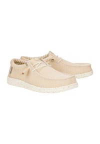 Beige Leinenschuhe mit einer strukturierten Oberseite, runder Zehenpartie und gewebten Schnürsenkeln. Cremefarben gesprenkelte Gummisohle. Innen mit gestreiftem Futter.