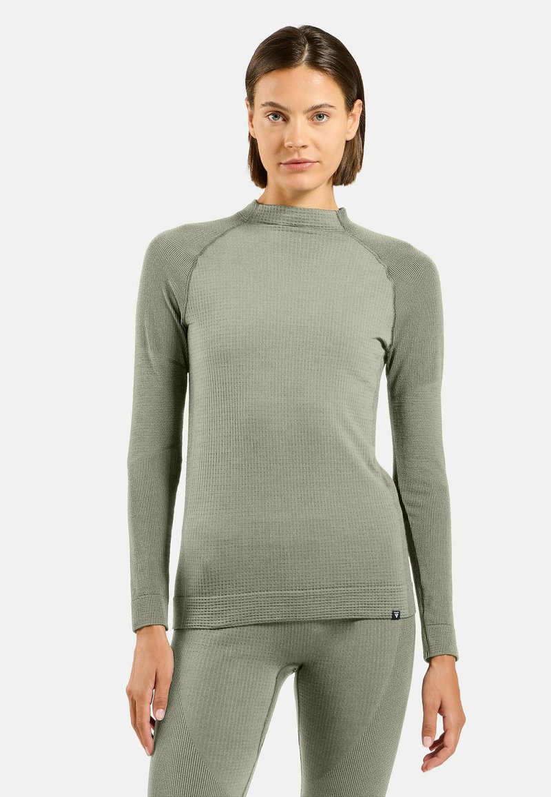 Chemise à manches longues vert clair en tissu texturé avec un design ajusté. Présente des manches raglan et une texture côtelée pour plus de détails.