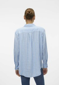 Long-sleeve shirt in light blue with white vertical stripes. Features a relaxed fit, buttoned cuffs, and a classic collar design.