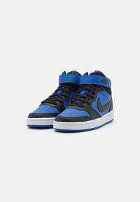 Mid-top Nike sneakers med svart base og blå detaljer, med perforerte tær, en borrelåsrem og en hvit såle.