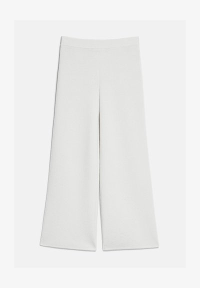 Pantalon blanc à jambes larges avec taille haute et sans attaches visibles, présenté à plat sur un fond clair.
