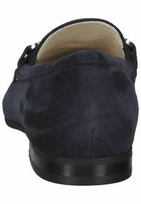 Scarpa slip-on in suede blu navy con punta tonda, texture liscia e suola piatta nera. Presenta un tallone corto e pochi dettagli in metallo.
