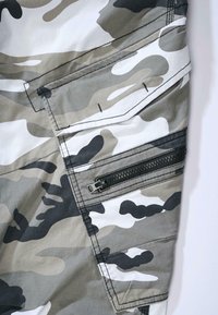 Pantalons cargo camouflage dans des nuances de gris et de blanc, dotés d'une poche zippée, de poches latérales et d'un tissu texturé avec une finition mate.