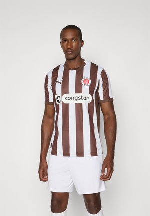 Brown and white vertically striped football shirt with a round neckline and brand logo. Worn with white shorts, featuring a sponsor logo.