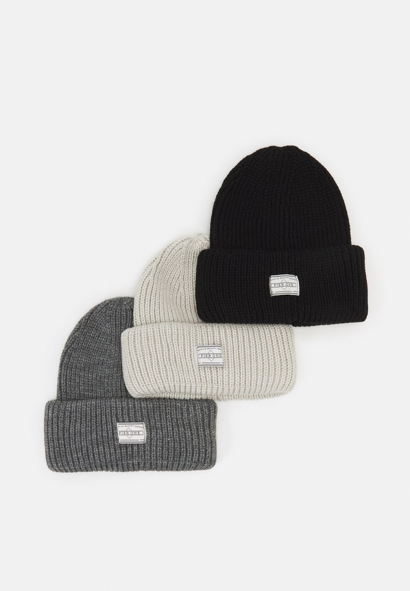 Conjunto de gorros de punto acanalado en negro, gris y blanco roto. Cada uno cuenta con un dobladillo en la parte superior y una pequeña etiqueta de la marca en la parte delantera.
