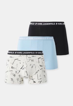 Zestaw trzech slipów: czarne, jasnoniebieskie i kremowe, z abstrakcyjnymi czarnymi wzorami. Każdy z nich ma elastyczny pasek z logo.