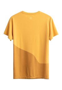 Geel T-shirt met een zachte textuur en een gebogen ontwerp in een donkerdere tint. Scharen grafiek geborduurd op de neklijn aan de achterkant.