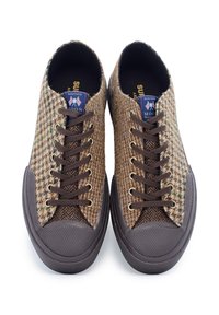 Bruine sneakers met patroon, gemaakt van geweven stof, met donkerbruine veters, ronde neus, rubberen zool en een merklabel op de tong.