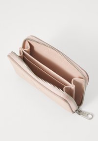 Calvin Klein džinsų užtrauktuko piniginė švelniai rožinės spalvos, su dviem skyriais, sidabrinėmis užtrauktuko detalėmis ir įspaustu logotipu viduje.