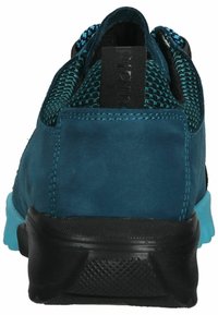 Türkisfarbene Sportschuhe mit einer strukturierten Obermaterial, schwarzen Akzenten und einer Gummisohle mit blauen Highlights. Die Rückansicht zeigt eine Schlaufe zum Einsteigen.