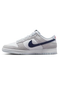 Nike Dunk Low sneaker i vit och grå läder med blå accenter, med en slät yta och rund tå. Ljusgrå sula.