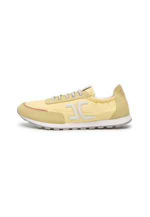 Yellow and beige low-top sneaker with white laces, white logo on side, and white rubber sole with tread pattern.