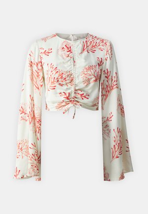 Hvit kort topp med rødt korallmønster, rynket front og lange bell-sleeves. Glatt stofffinish og knytte-detaljering ved kanten.
