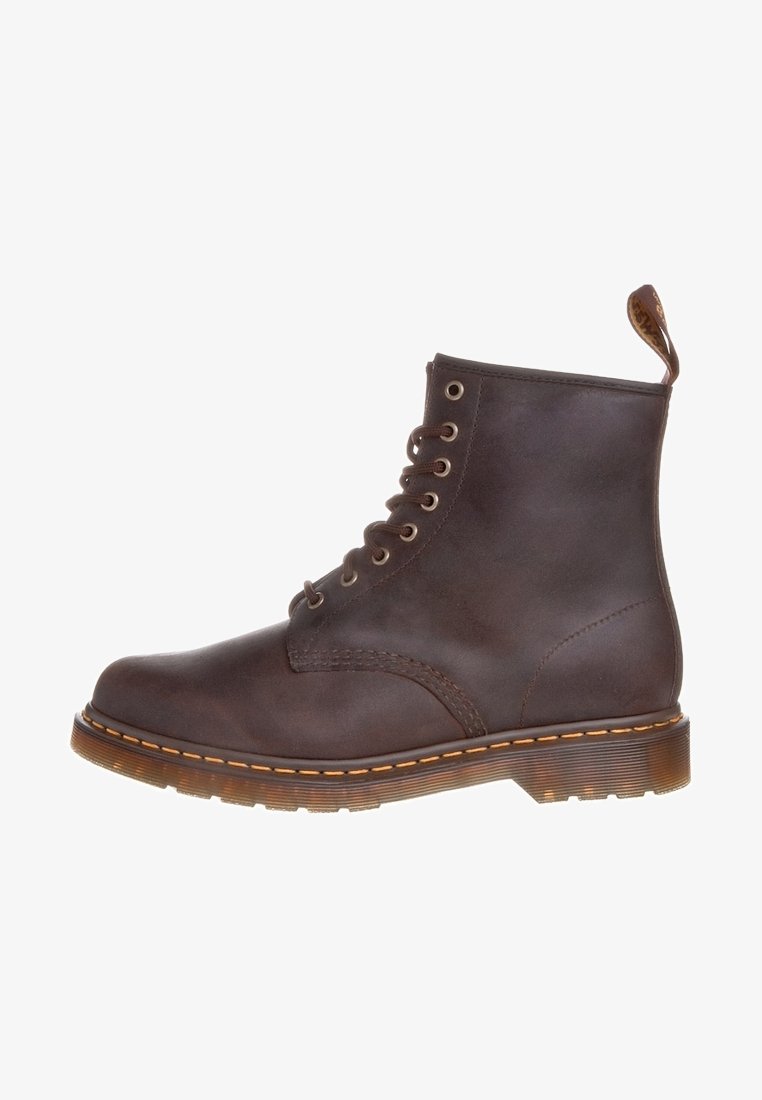 Botte montante en cuir marron à lacets, avec une semelle épaisse translucide et des coutures jaunes, dotée d'une languette à l'arrière.