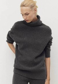 Dark gray, oversized sweater with a high, rolled neckline and loose-fitting sleeves. Made of soft, textured knit material.