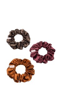 Drie satijnen scrunchies: donkerbruin, roestoranje en diep bordeauxrood. Elke scrunchie heeft een verzameld ontwerp en een klein logotag.