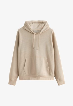 Beige huppari ribbitekstuuriin, jossa on etutasku ja nyöri. Ominaisuudet: pitkät hihnat ja rento istuvuus.