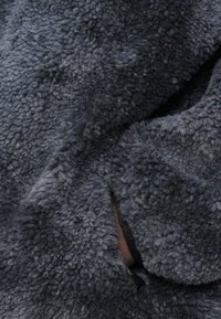 Grauweicher Plüschfleece-Stoff mit einer sanften, strukturierten Oberfläche. Besitzt einen lockeren Fall und eine dunkle Farbe mit subtilen Nuancen in den Schattierungen.