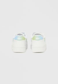 Valkoiset tennarit vaaleansinisin ja vihrein yksityiskohdin, joissa on sileä pinta, pyöreä muoto ja tunnistettava logo kantapäässä.