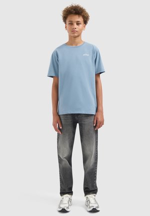 Lichtblauwe katoenen T-shirt, ronde halslijn, korte mouwen. Draag het met grijze jeans met een vervaagde wassing en witte sportschoenen.