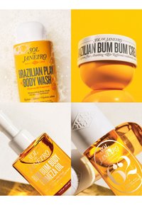 Gele en witte Sol de Janeiro lichaamsverzorgingsproducten, waaronder Brazilian Body Wash, Bum Bum Cream, Firm Body Firming Oil en Cheirosa 62 Perfume Mist.