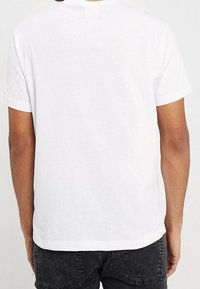 White cotton t-shirt with a crew neckline and short sleeves, featuring a plain design and a straight-cut hem. No visible logos or patterns.