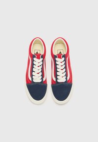 Red and navy suede sneakers with white laces, featuring a rounded toe and a classic side stripe design. Rubber outsole with textured surface.