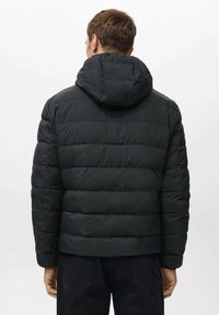 Zwarte donzen jas met capuchon, voorzien van een doorgestikt ontwerp en zichtbare naden. Simpel en functioneel zonder versieringen.