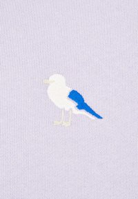 Purple knit fabric featuring an embroidered bird design in white and blue, showcasing fine stitching with minimal texture.