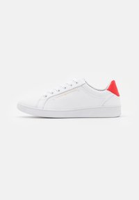 Bílé nízké tenisky s bílými tkaničkami, červeným patním tabem, zlatým logem Tommy Hilfiger na boční straně a bílou podrážkou na bílém pozadí.