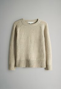 Beżowy sweter robiony na drutach z okrągłym dekoltem, ściągaczami na mankietach i u dołu. Miękka faktura oraz długie rękawy, z ramionami w stylu raglan.