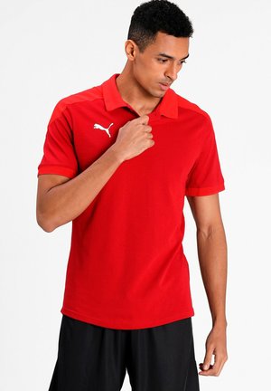 Cămașă polo roșie cu mâneci scurte, guler și logo alb Puma. Material neted cu un design ajustat, asortată cu pantaloni scurți negri.