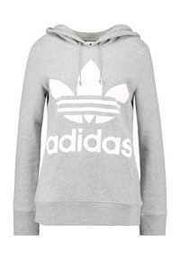 Grå hoodie med en framficka i kängurustil, snörning i huvan och stor vit Adidas-logotyp med tre ränder och lövdesign.