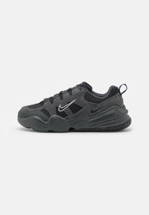 Scarpa da atletica nera e grigia caratterizzata da una tomaia testurizzata, tessuto perforato, design con lacci e suola in gomma spessa con motivi a onde.