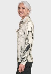 Langarm-Oberteil im weißen und schwarzen Marmor-Muster, aus leichtem Stoff gefertigt, mit hohem Kragen und tailliertem Design.