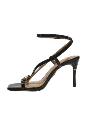 Black patent leather high-heeled sandal with ankle strap, square toe, and gold buckle detail on front strap.