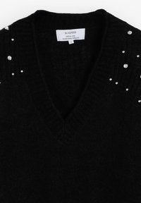 Suéter negro de punto con un diseño de escote en V, que presenta pequeños acentos de strass en los hombros. Fabricado con un hilo suave y texturizado.