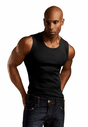 Schwarzes, ärmelloses Tanktop aus Baumwolle mit Rundhalsausschnitt und figurbetonendem Design, kombiniert mit dunklen Jeans aus Denim mit Nähakzenten.