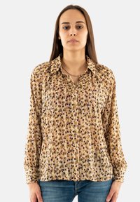 Blusa a maniche lunghe con colletto in tessuto leggero e fantasia, caratterizzata da tonalità di beige, marrone e viola, con chiusura a bottoni e maniche con polsini.
