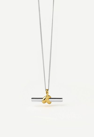 Pendentif barre horizontale en argent avec un petit détail de nœud doré suspendu à une fine chaîne en argent sur un fond clair.