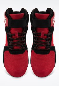 Sarkanas un melnas augstas sporta čības ar teksturētu audumu, pastiprinātu potīšu atbalstu un melnām šņorēm, ar logotipu sānos.