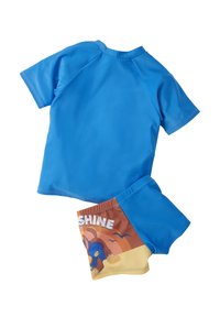 Maglietta da nuoto a maniche corte blu realizzata in materiale elastico, abbinata a un costume da bagno colorato con un design a cartone animato e testo "SUNSHINE".