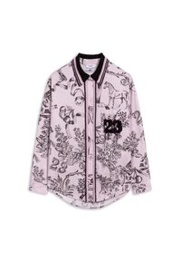 Jasnoróżowa koszula z czarnymi, szczegółowymi ilustracjami zwierząt i roślinności. Zawiera czarny kołnierzyk oraz haftowany numer „23” na kieszeni.