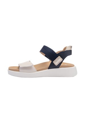 Sandal with navy fabric straps, white synthetic accents, and a light tan footbed. Features adjustable Velcro closures and a white platform sole.