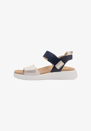 Sandal with navy fabric straps, white synthetic accents, and a light tan footbed. Features adjustable Velcro closures and a white platform sole.