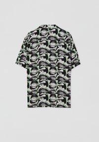 Chemise à manches courtes avec un fond noir orné d'un motif répétitif de divers traits du visage en tons blancs et verts.