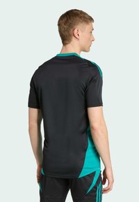 Camiseta deportiva negra con detalles en turquesa, con cuello redondo y mangas cortas. Textura suave y ligera, adecuada para el deporte.